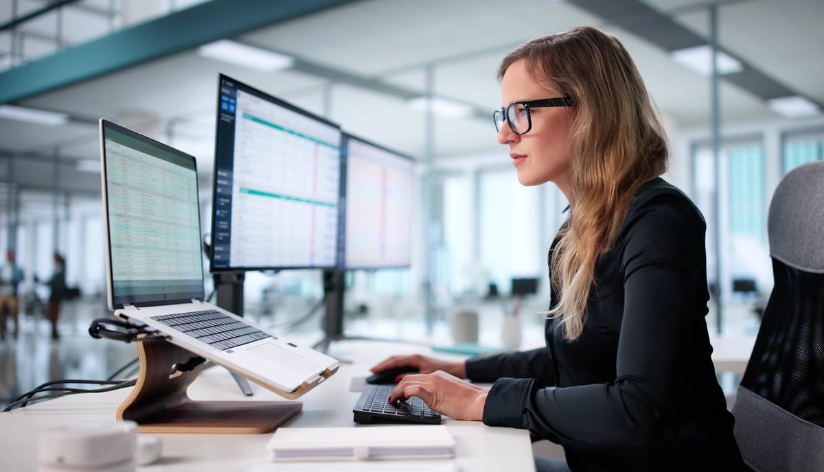 Finance professional monitoring billing codes and financial data on spreadsheets